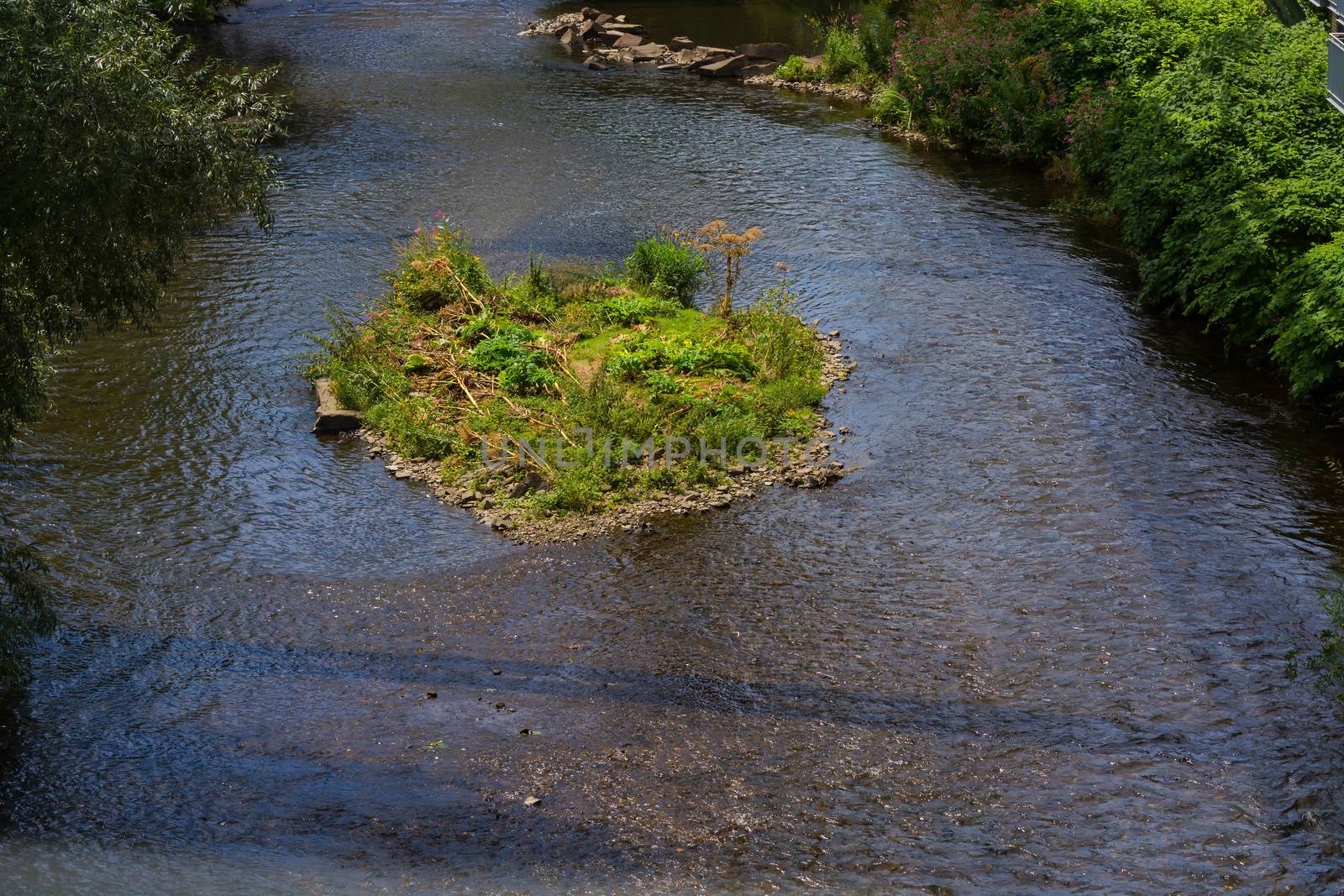 The river Wupper in Wuppertal, Germany with a small island in the river bed. Photographed from the suspension railway.