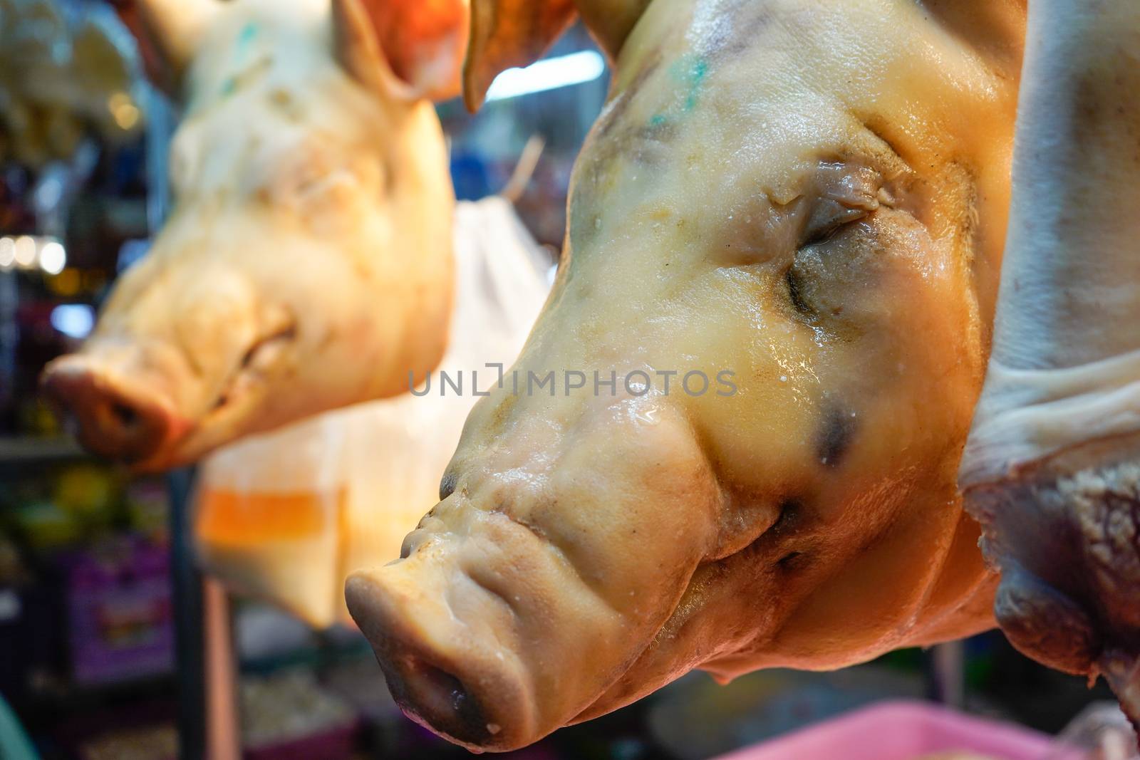 boiled pork heads hang in a butchers shop