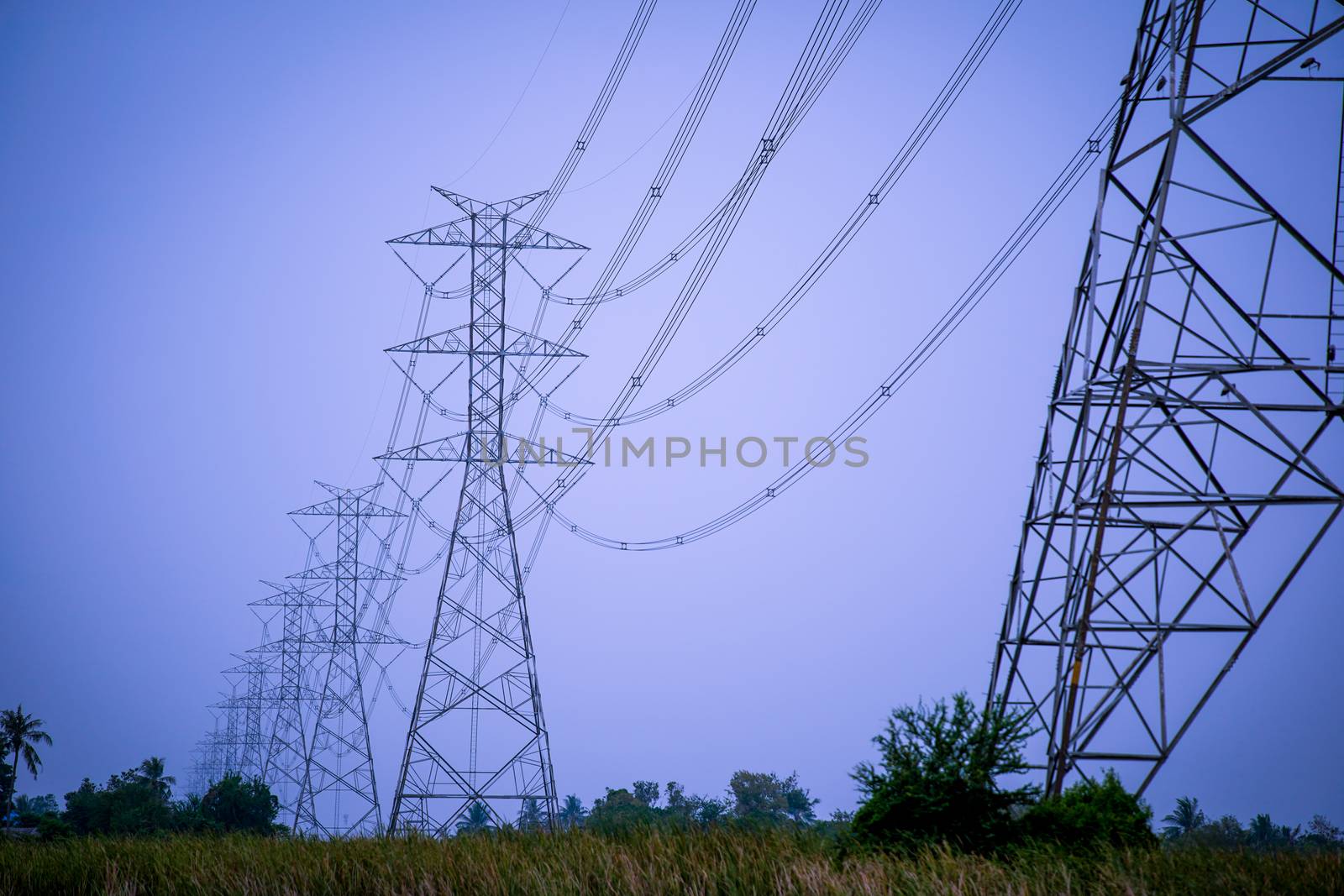 high voltage power lines during fiery sunset