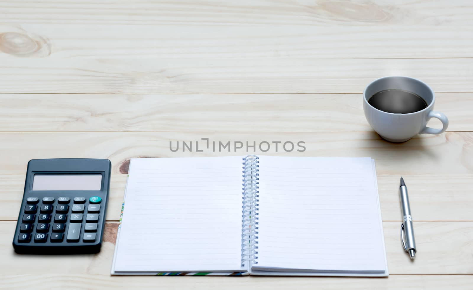Top view of pen with calculator and notebook on wooden table and copy space for insert text.