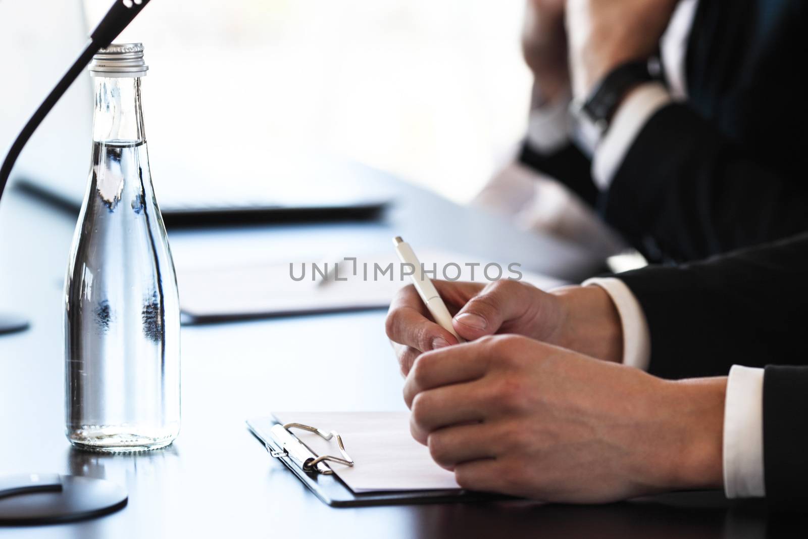 Group of speakers at business meeting at the table with microphones