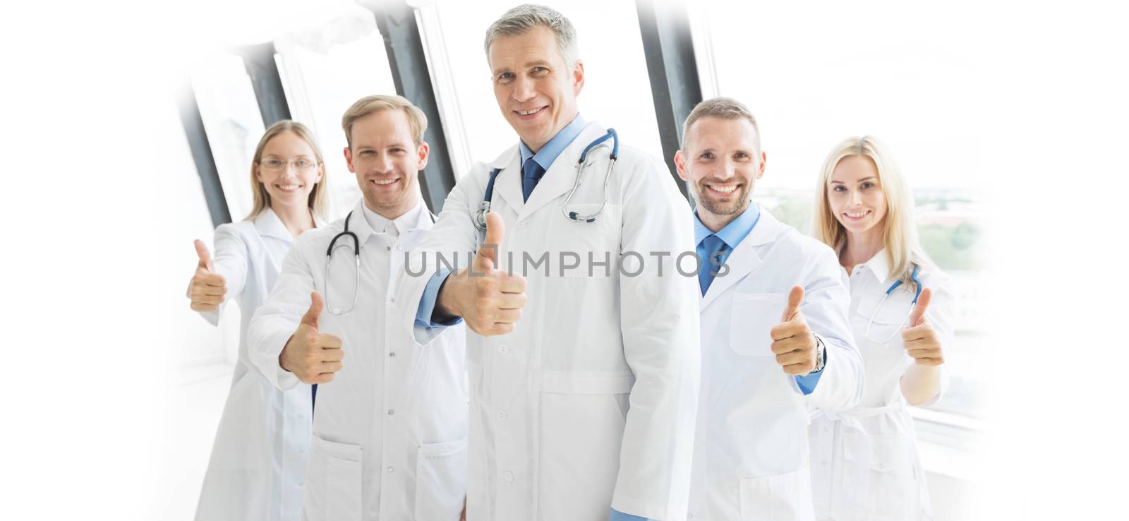 Medical team of doctors and in hospital showing thumbs up