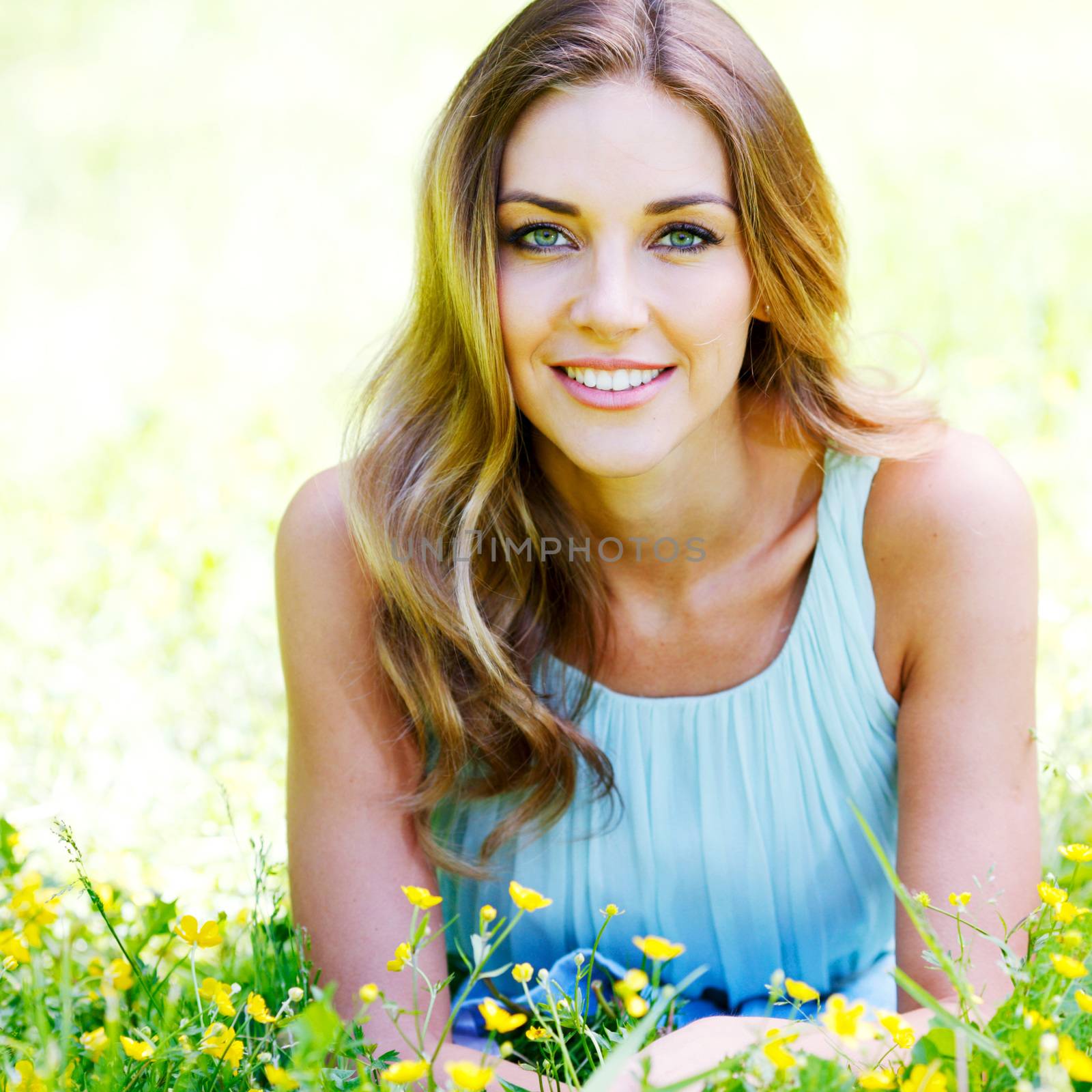 young woman in blue dress lying on grass by Yellowj