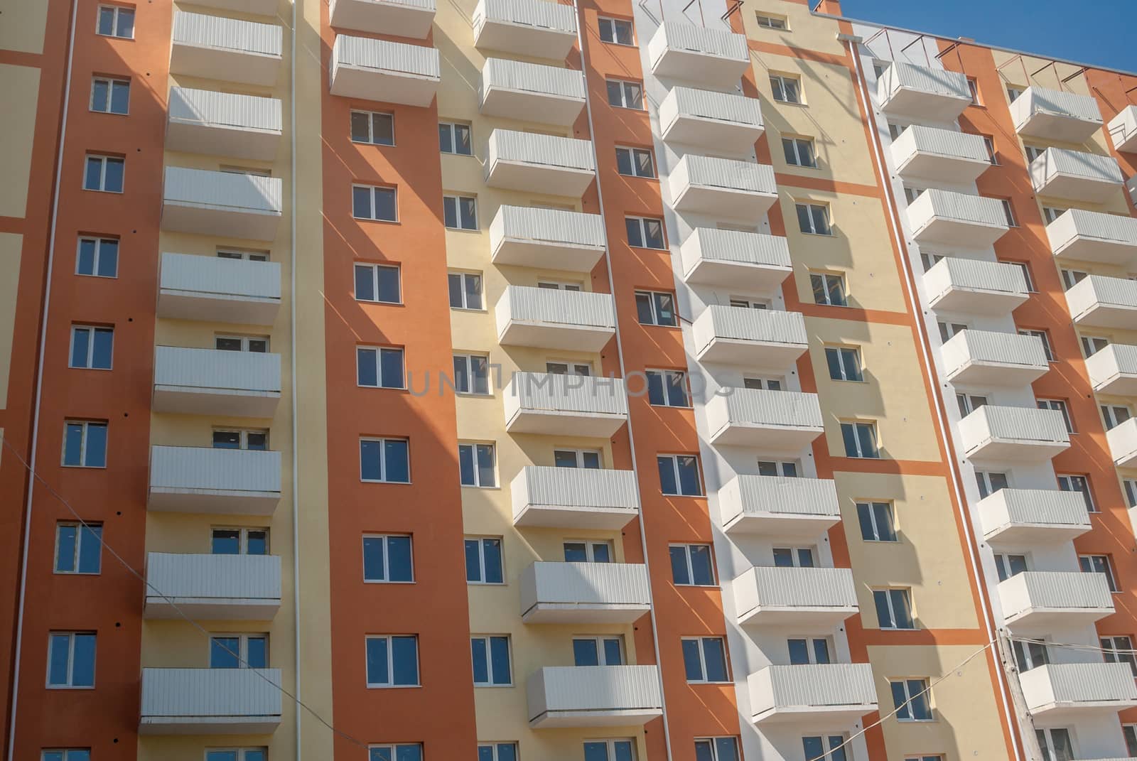 kind of a new multistorey brick residential building with balconies on a sunny day