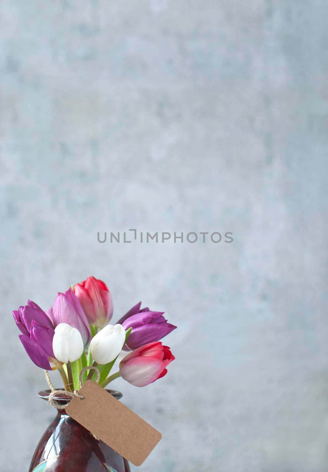 Selection of spring tulips with a gift label and space 