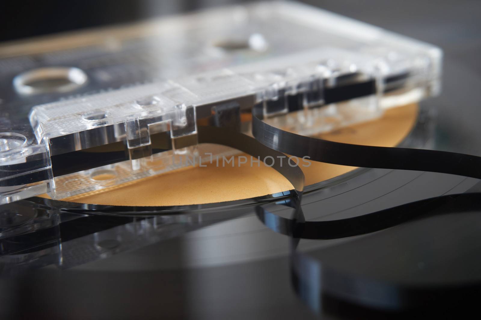 Retro audio cassette tape, long play vinyl record in background. Concept of vintage technologies.