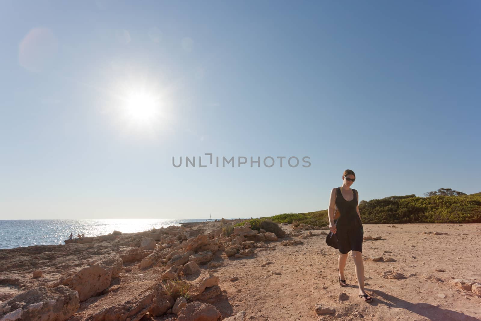 Cap de Ses Salines, Mallorca - A young woman going out for a wal by tagstiles.com