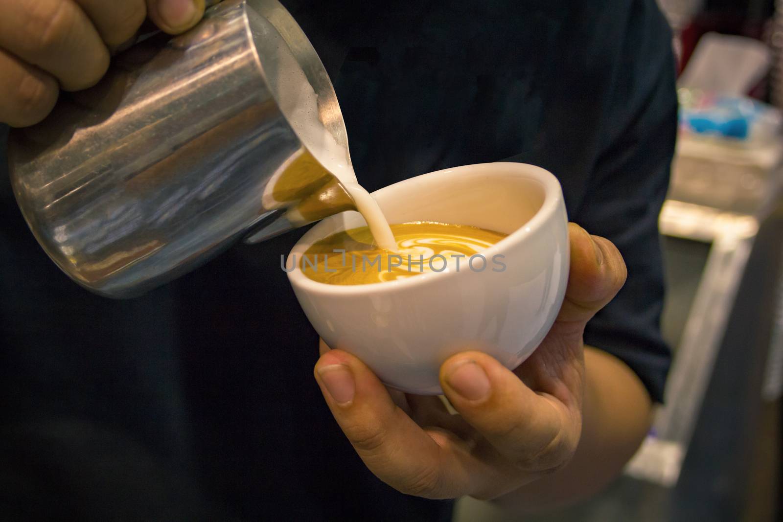 barista take the latte art in white mug, barista pours milk making cappuccino in cafe, barista creating latte art on long coffee with milk, Latte art in coffee mug, Barman pouring fresh coffee.