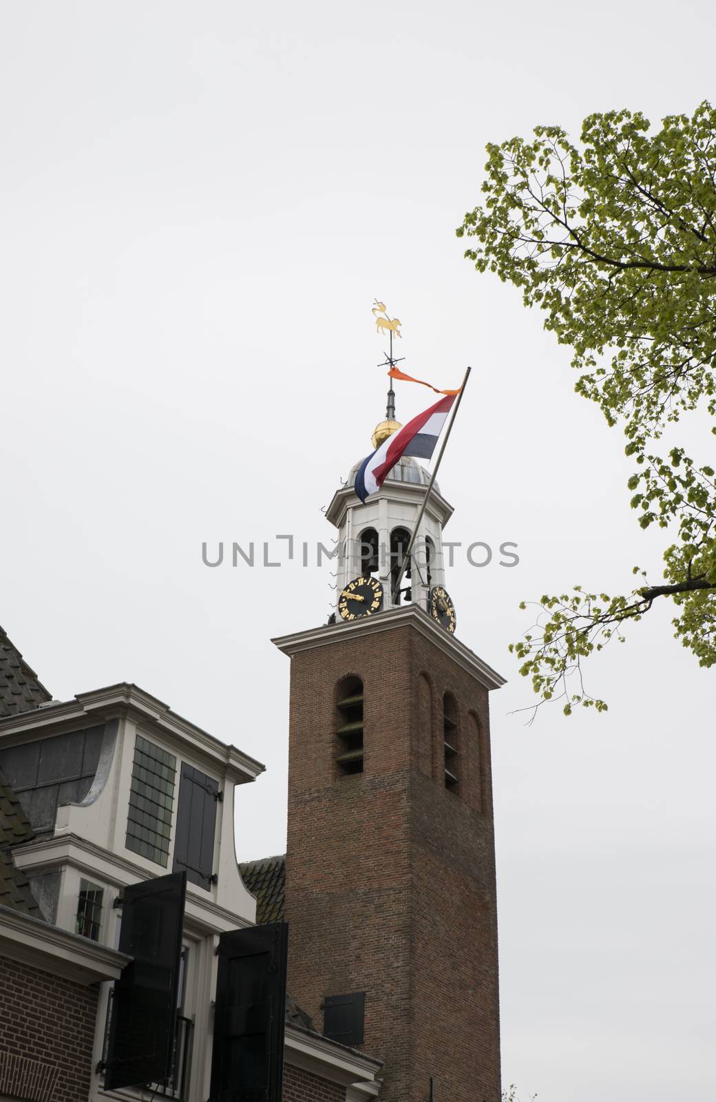 Dutch flag with orange streamer on the church of Hellevoetlsuis in the Netherlands, the orange streamer is only used when there is a celebration of the royal family
