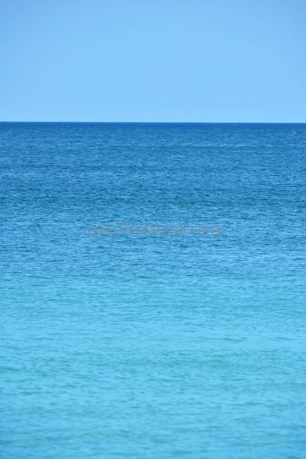 Tranquil seascape of blue sea water and clear sky with horizon, summer day, high angle view