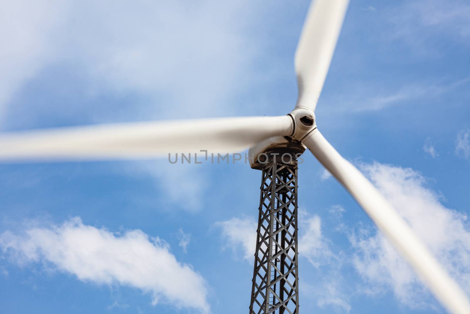 Single Wind Turbine Over Dramatic Blue Sky.