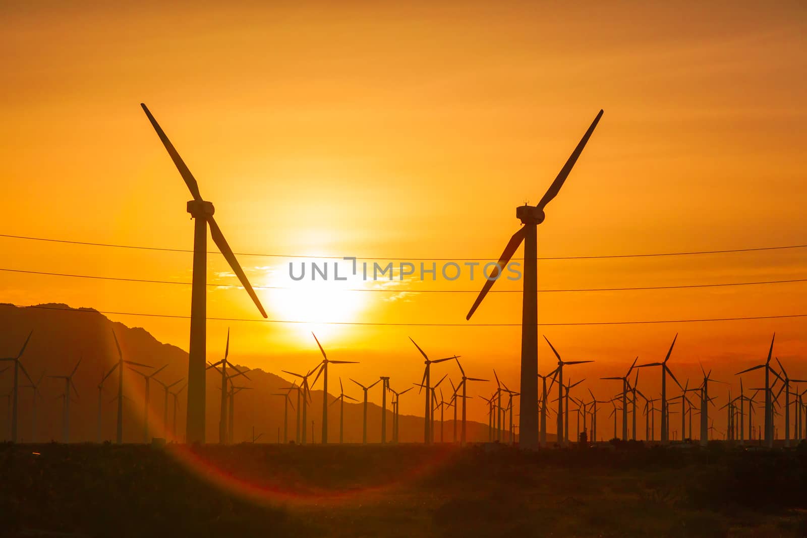 Silhouetted Wind Turbines Over Dramatic Sunset Sky.