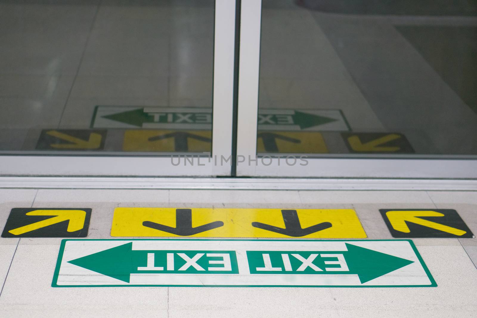 Direction and exit arrow sign at station with close door by eaglesky