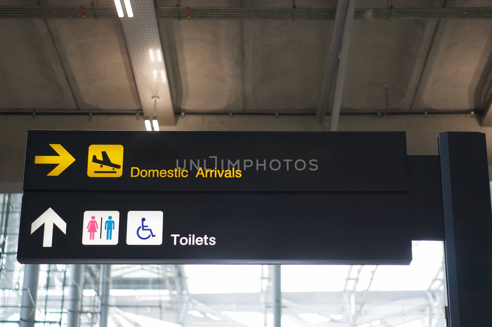 Domestic arrivals and toilets board sign at international airport by eaglesky