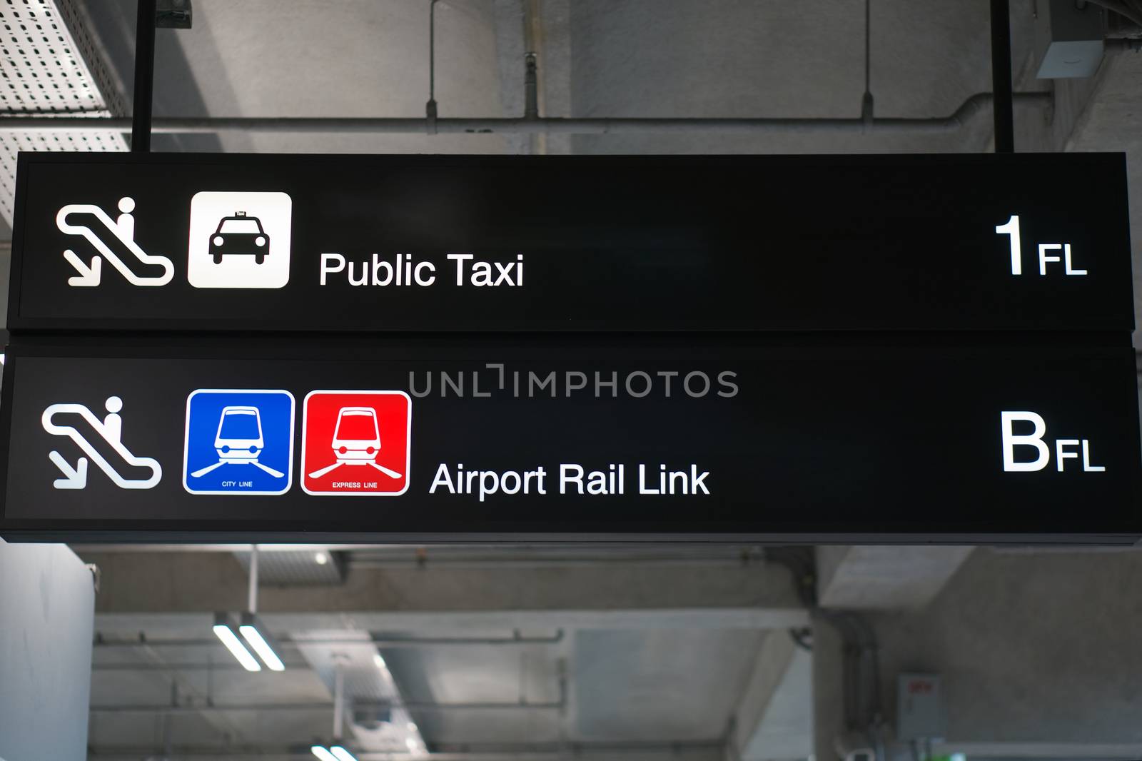 Public taxi and Airport rail link information board sign with white character on black background at international airport terminal.