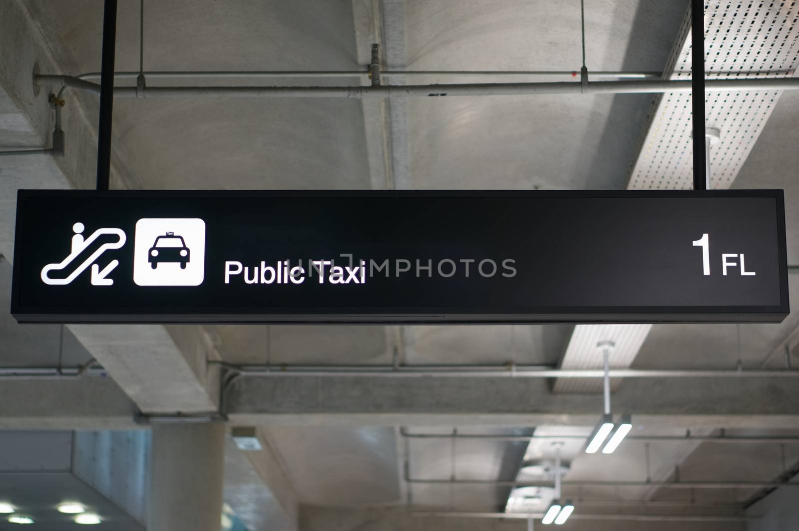 Public taxi information board sign with white character on black background at international airport terminal.