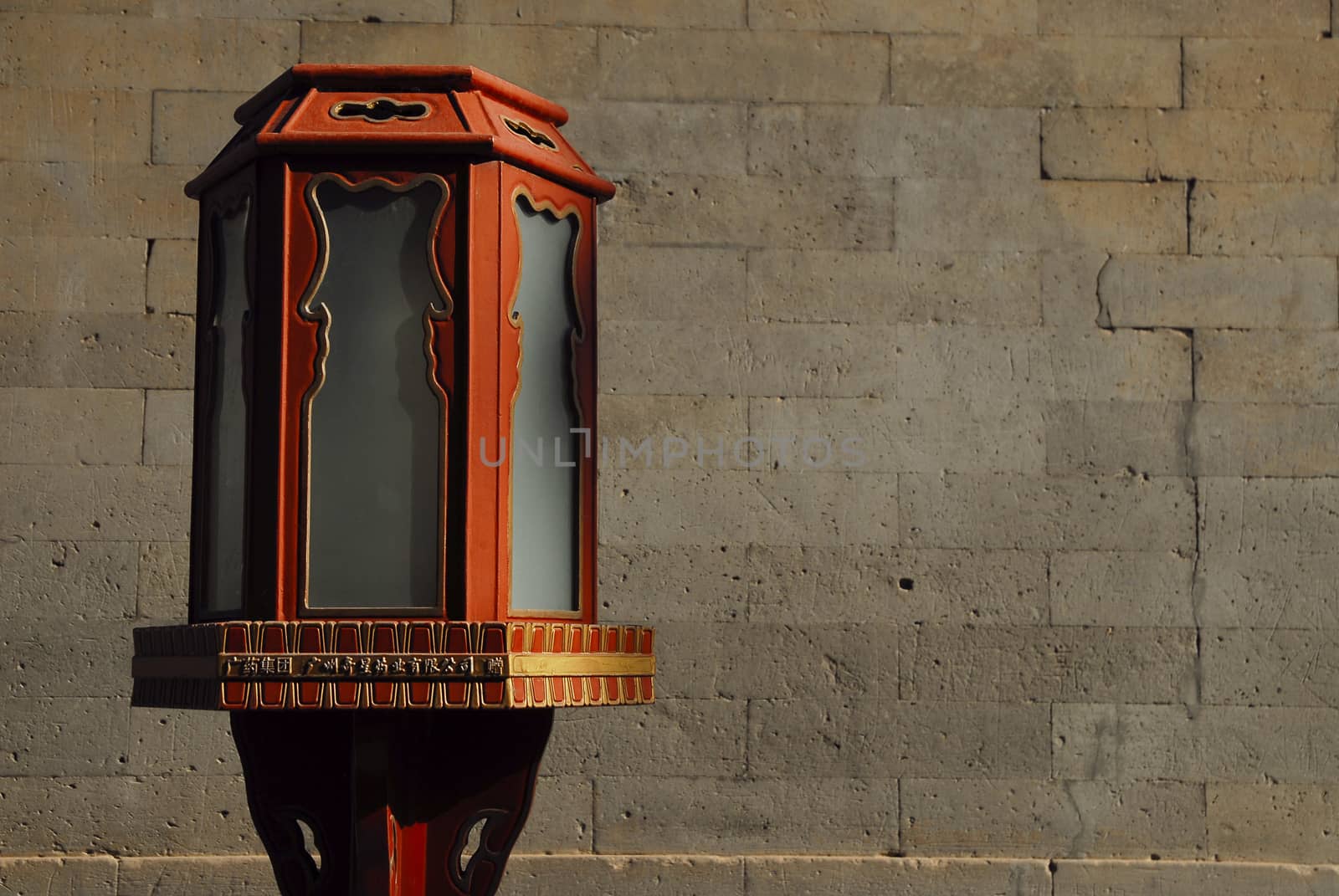 Chinese old lantern from Forbidden City. Ancient stone wall as a background.