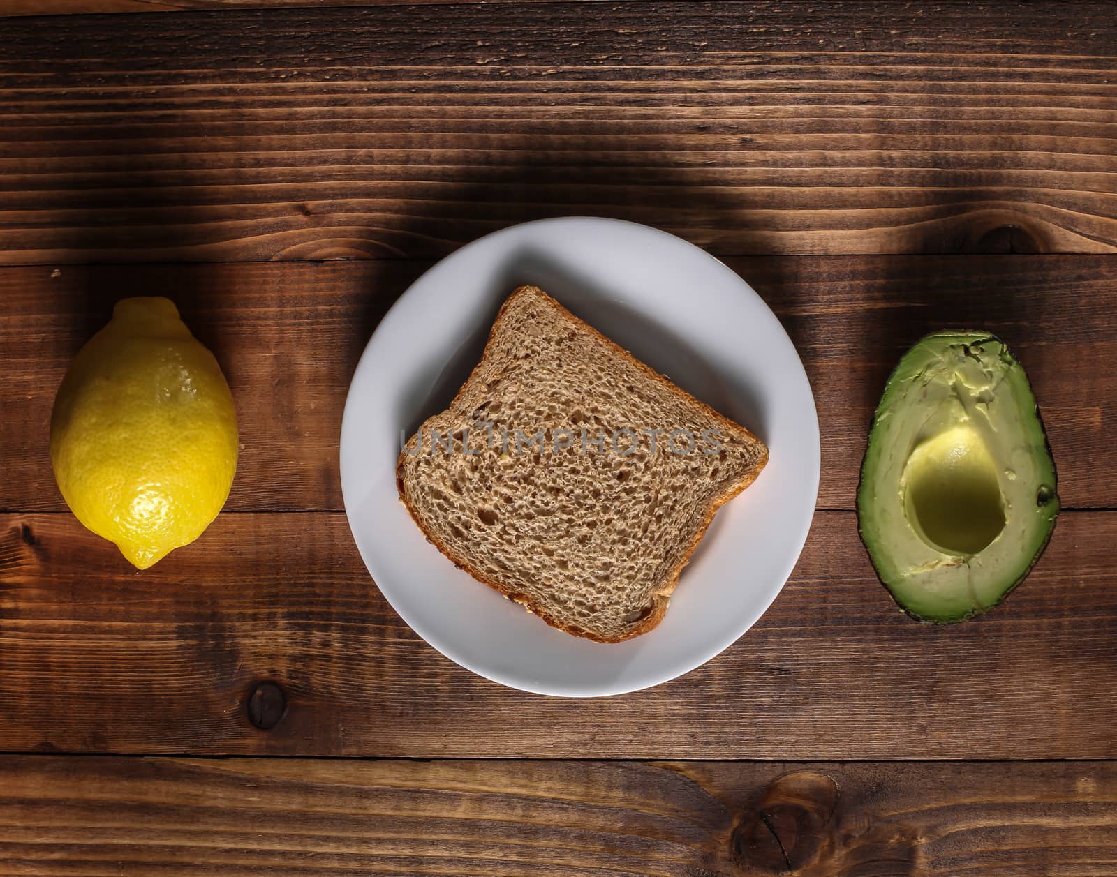 Table with lemon, avocado and bread