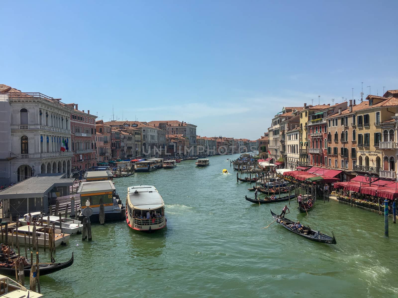 venice canal with boats and gondoliers by Tevion25