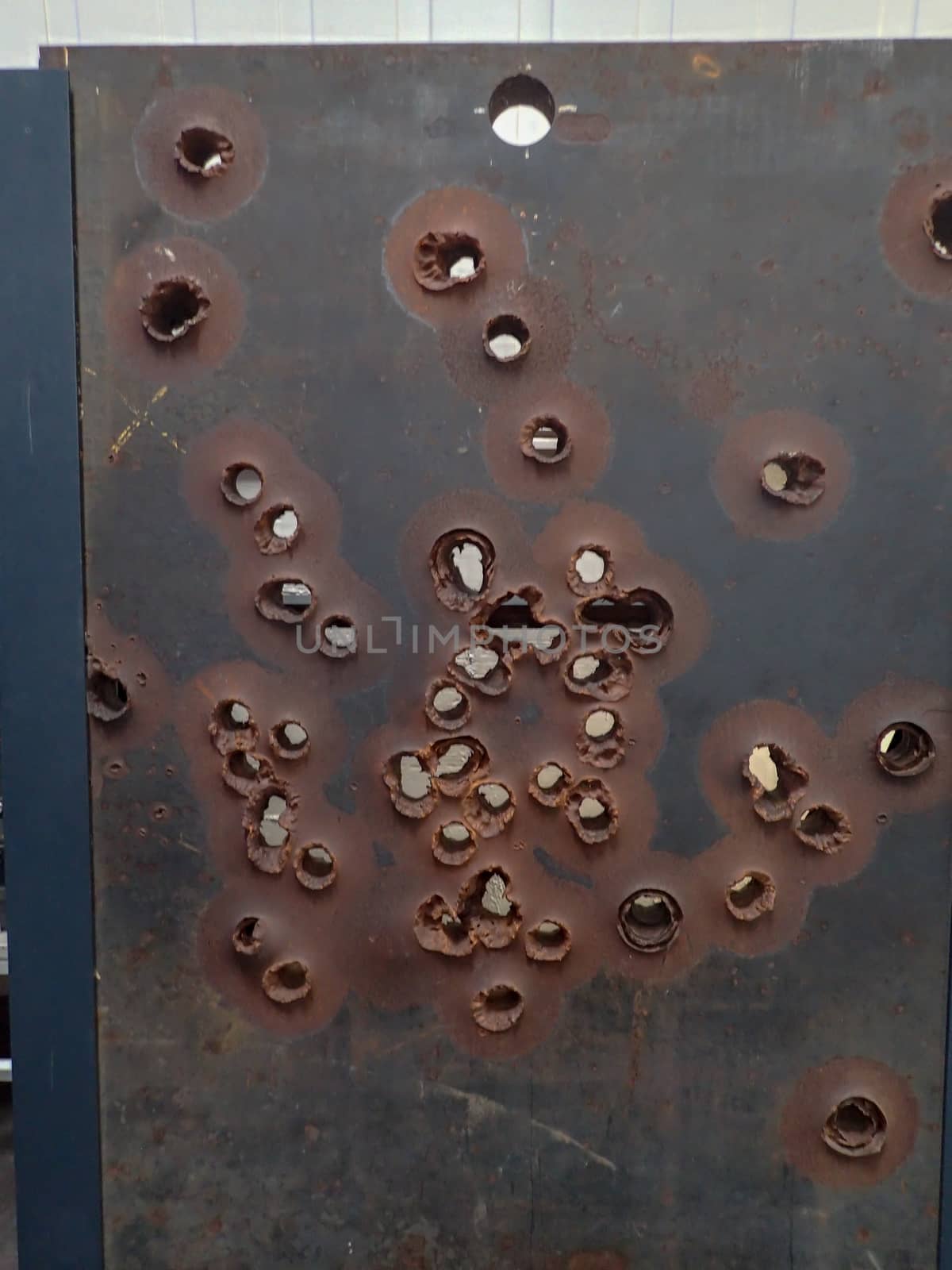 a steel wall with lots of bullets holes in a museum
