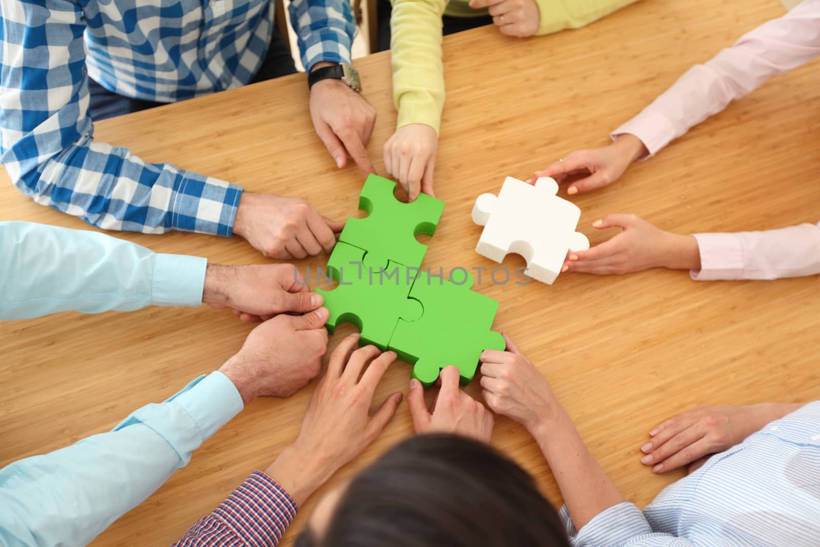 People assembling jigsaw puzzle by ALotOfPeople