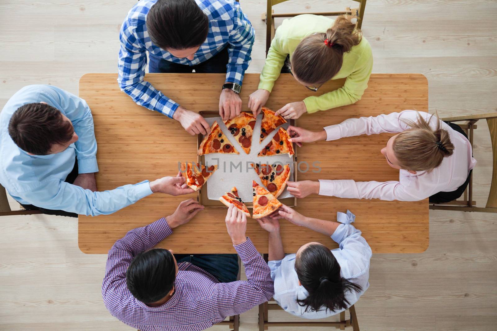 People hands grabbing pizza from delivery box, top view