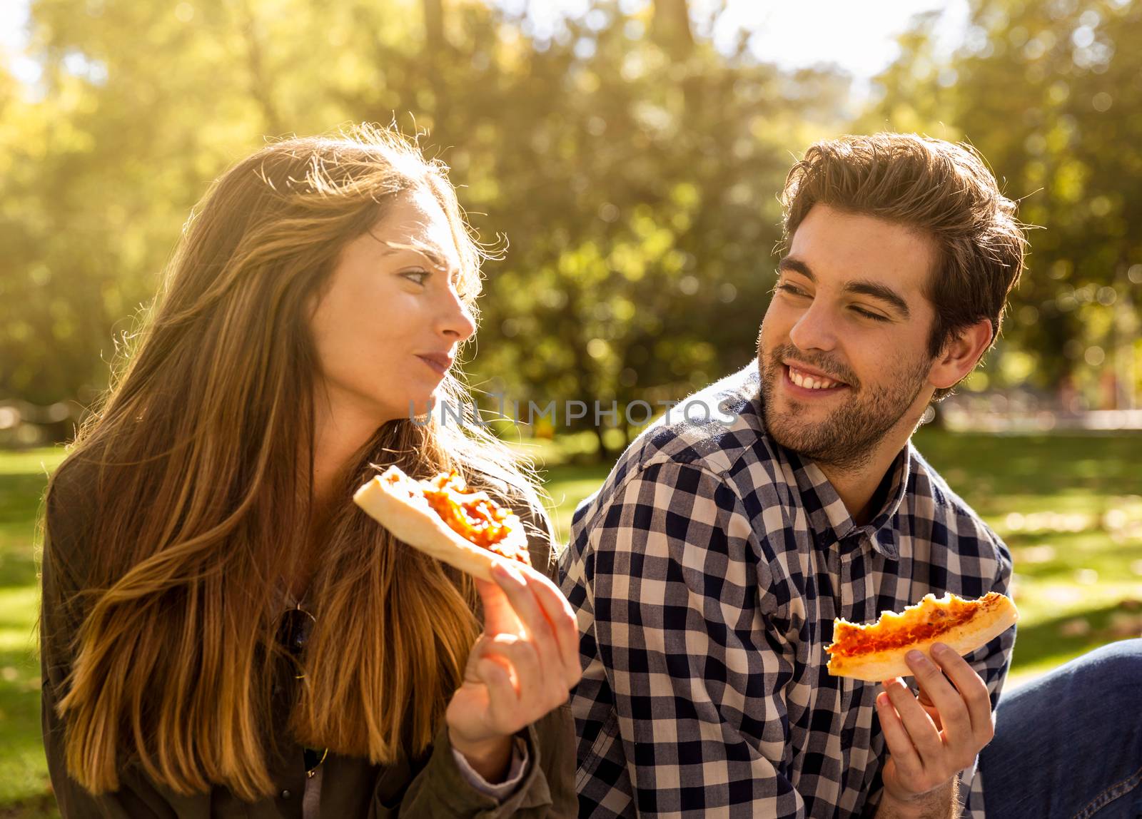 Friends at the park eating pizza