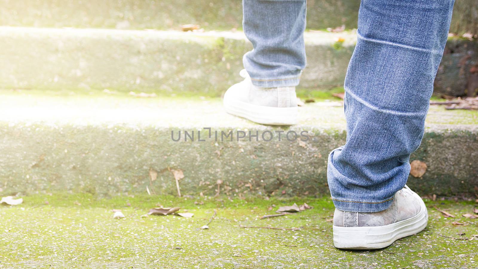 Feet Sneakers And Jeans Walking On Staircase Outdoor With Autumn Season Nature On Background Lifestyle Fashion Trendy Style, Walking In The Park Outdoors. by rakoptonLPN