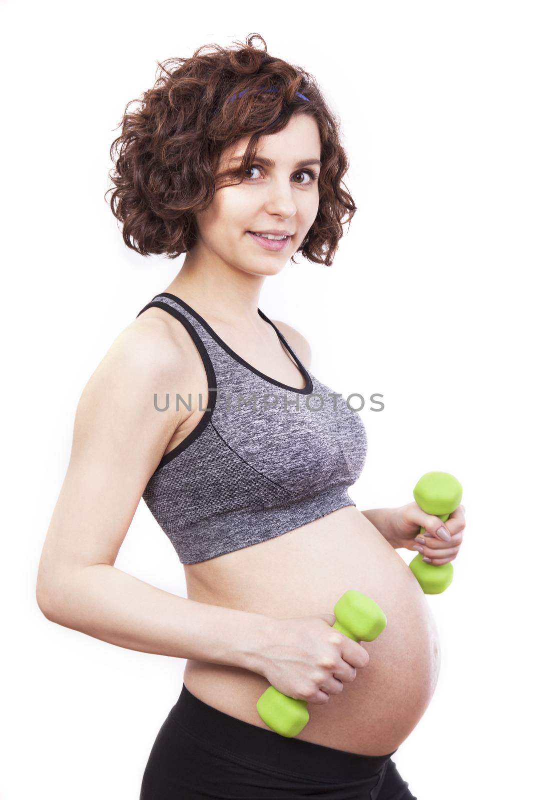 Young pregnant woman practicing fitness. Isolated on white background