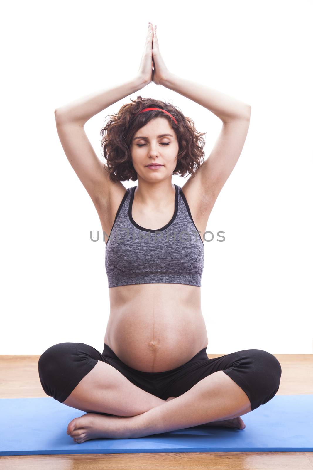 Young pregnant woman practicing fitness. Isolated on white background