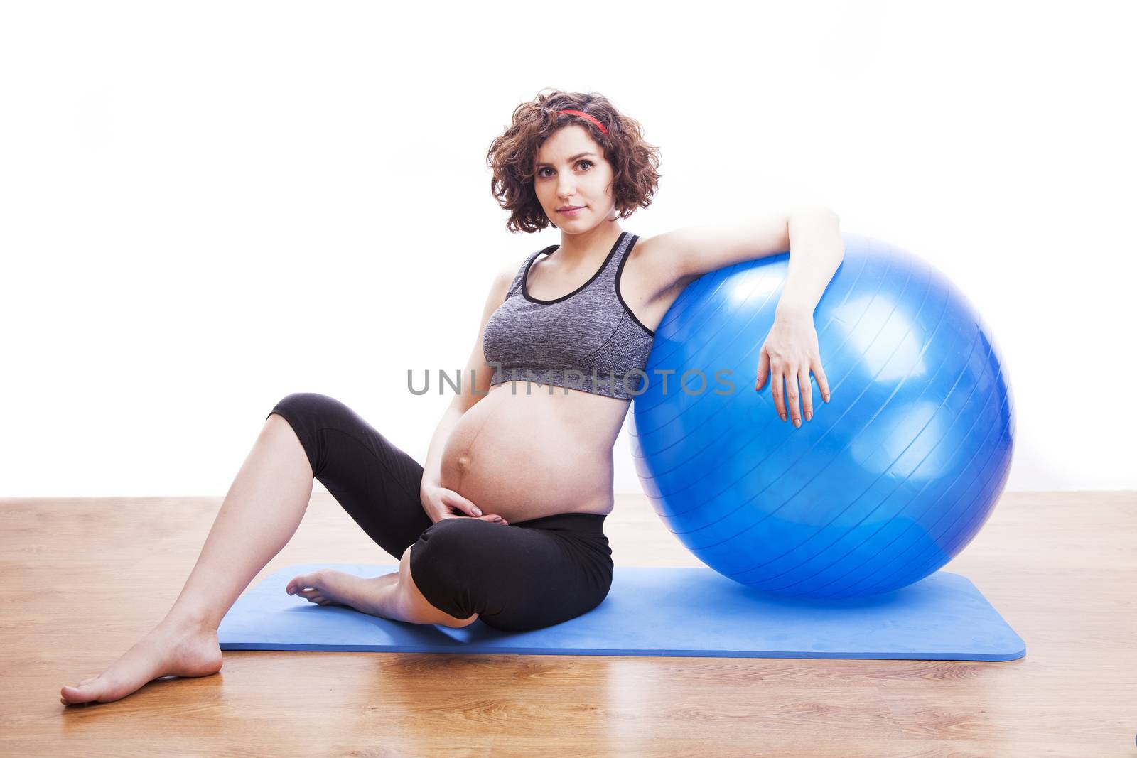 Young pregnant woman exercises with the ball.