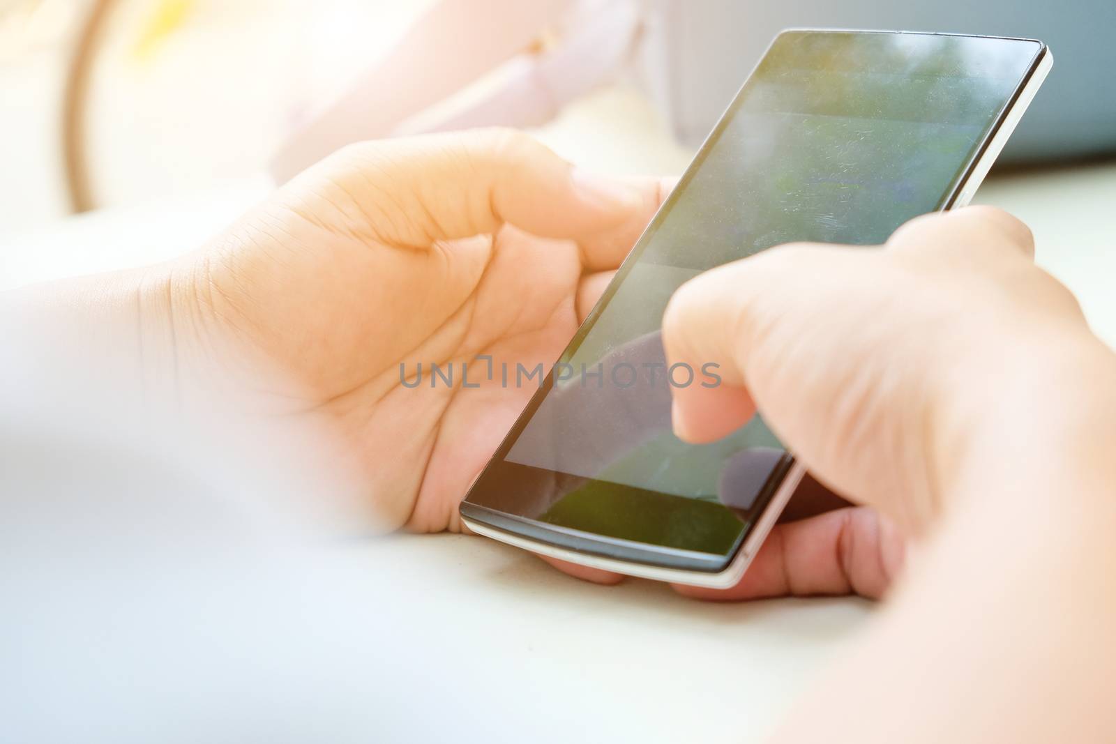 Close-up of female hands using smart phone with flare light background. Searching Internet ,Social Networking Concept