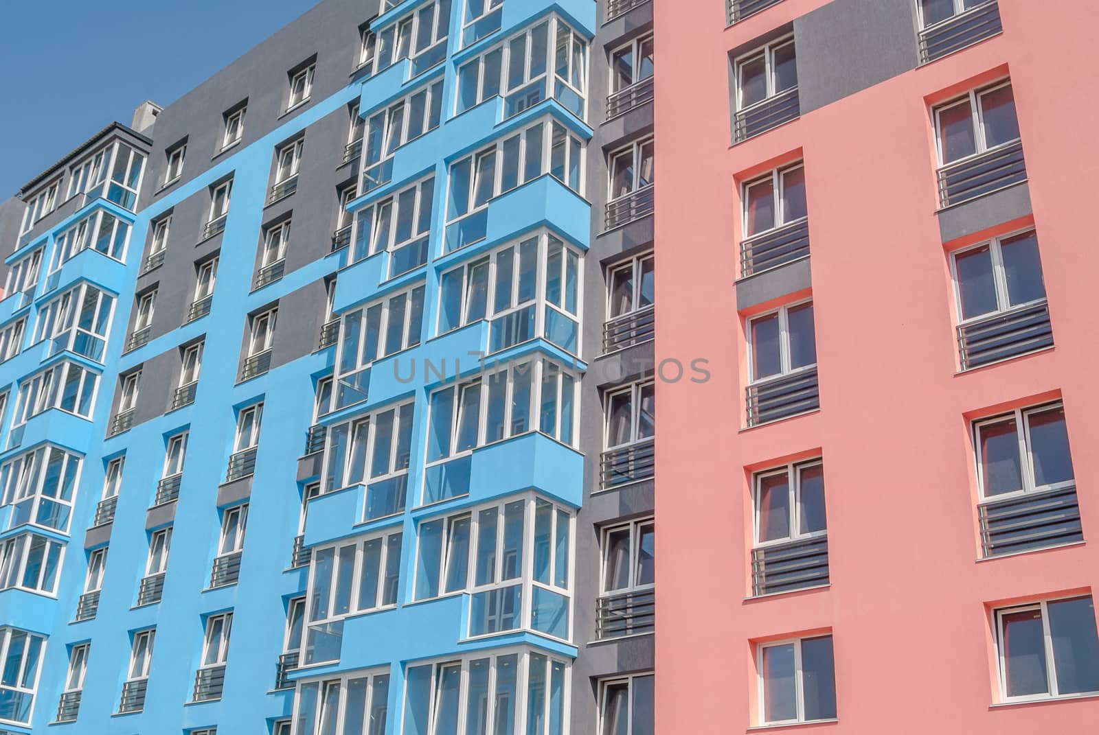 kind of a new multistorey brick residential building with balconies on a sunny day