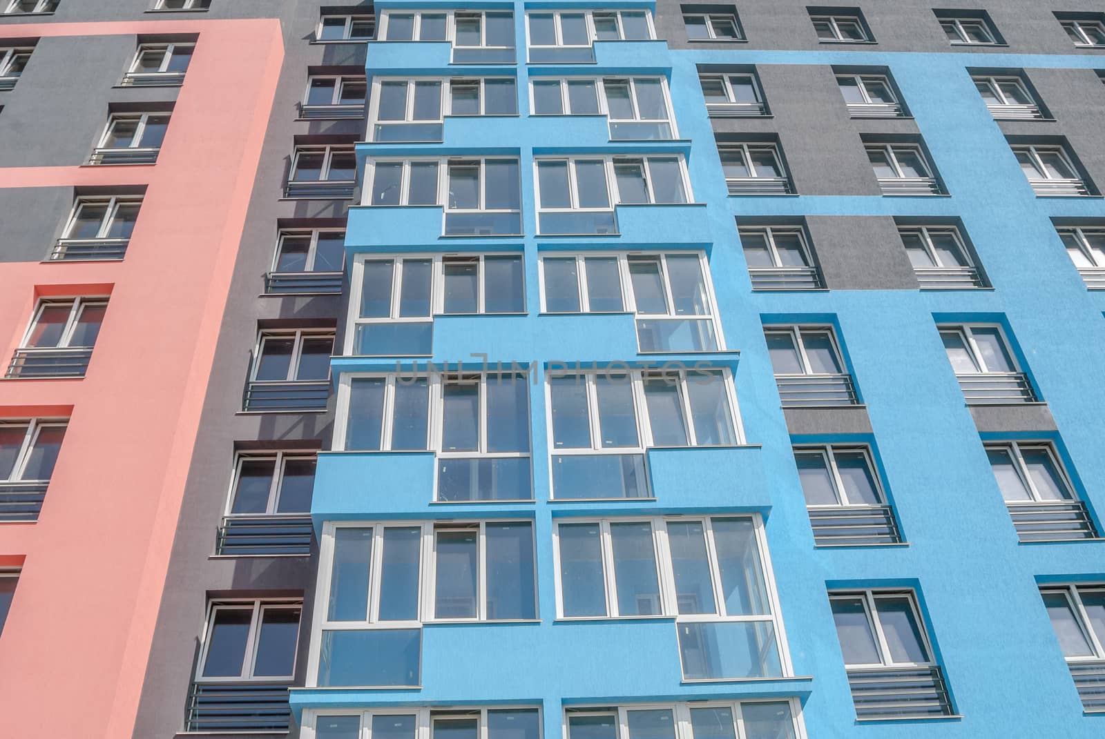 kind of a new multistorey brick residential building with balconies on a sunny day