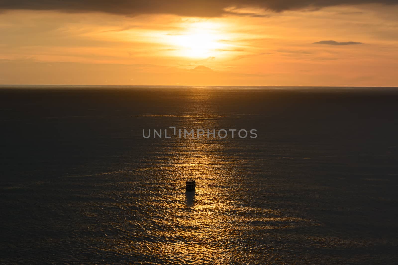 Old ancient ship on peaceful ocean at sunset. Calm waves reflect by ahimaone
