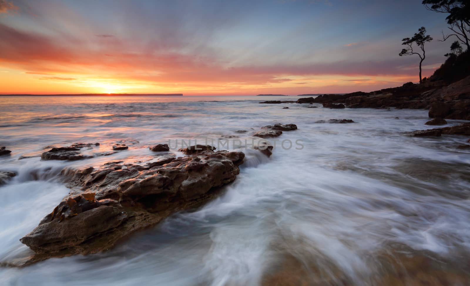 Sunrise over the Bay with ocean over rocks by lovleah