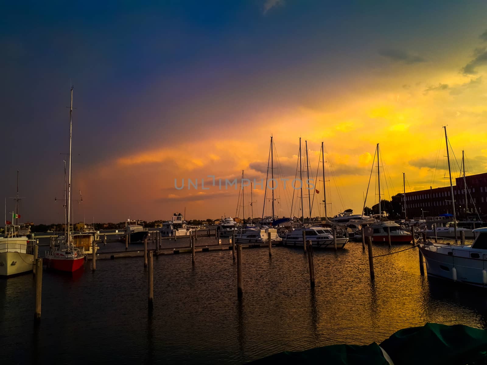 sunset in venice with boats in the pier by Tevion25