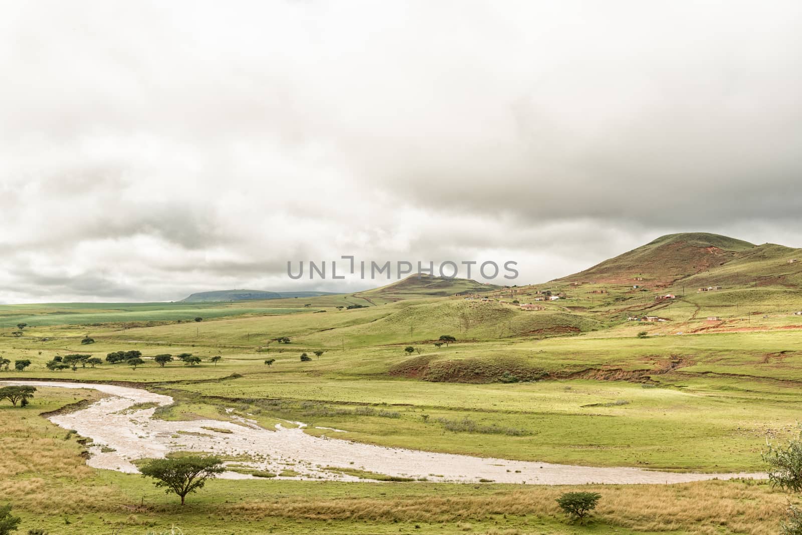 The Tugela River with a township in the back. The river forms the border of the Maloti Drakensberg Park at this point