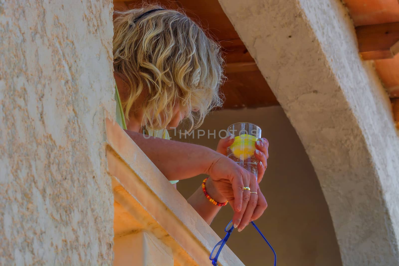 Woman relaxing on a Mediterranean balcony.     by JFsPic