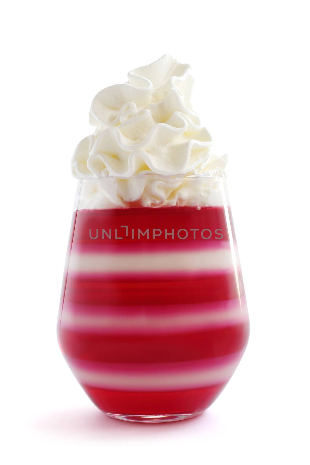 Red striped jello dessert in glass with whipped cream on top isolated on white background