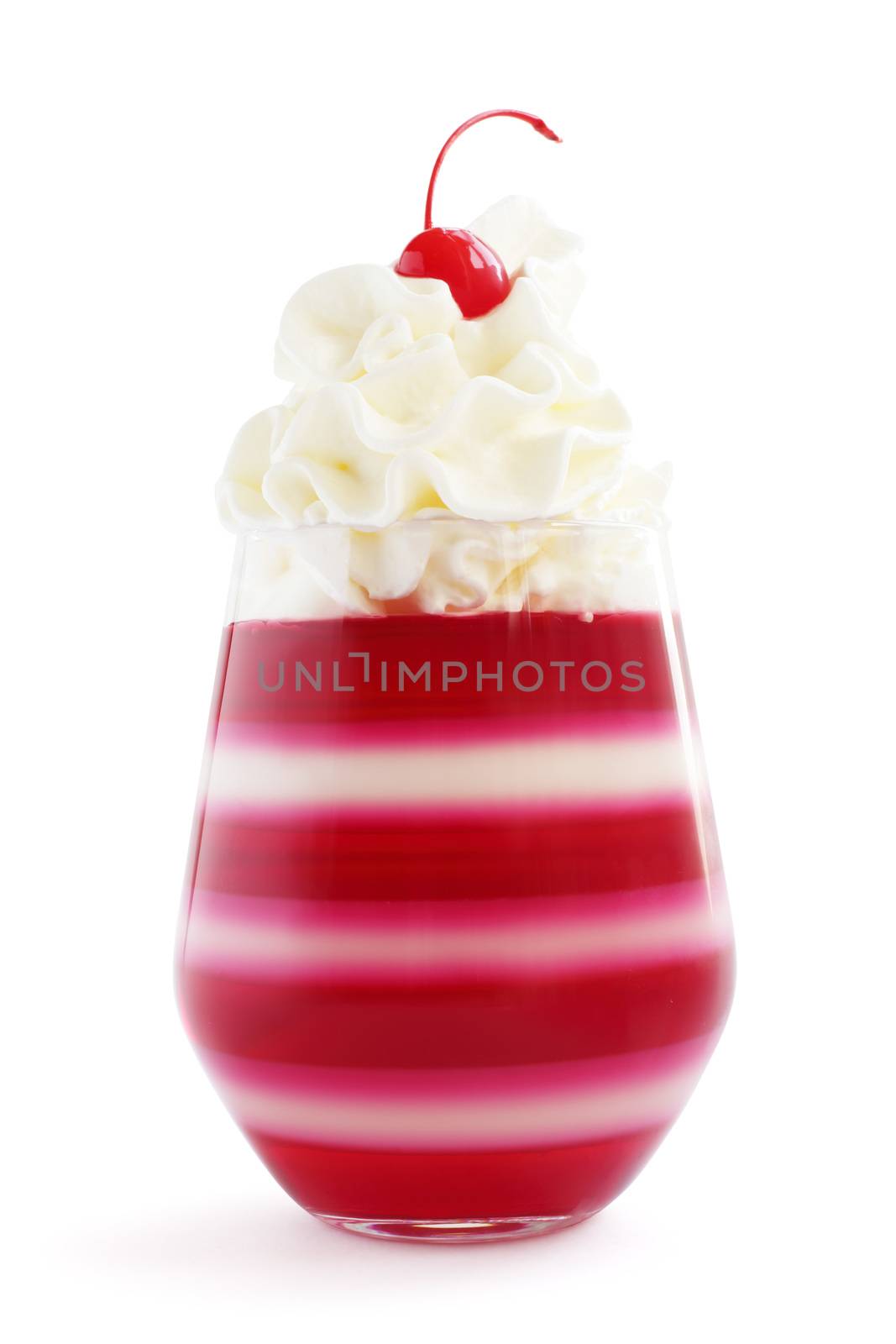 Red striped jello dessert in glass with whipped cream and red candied cherry on top isolated on white background