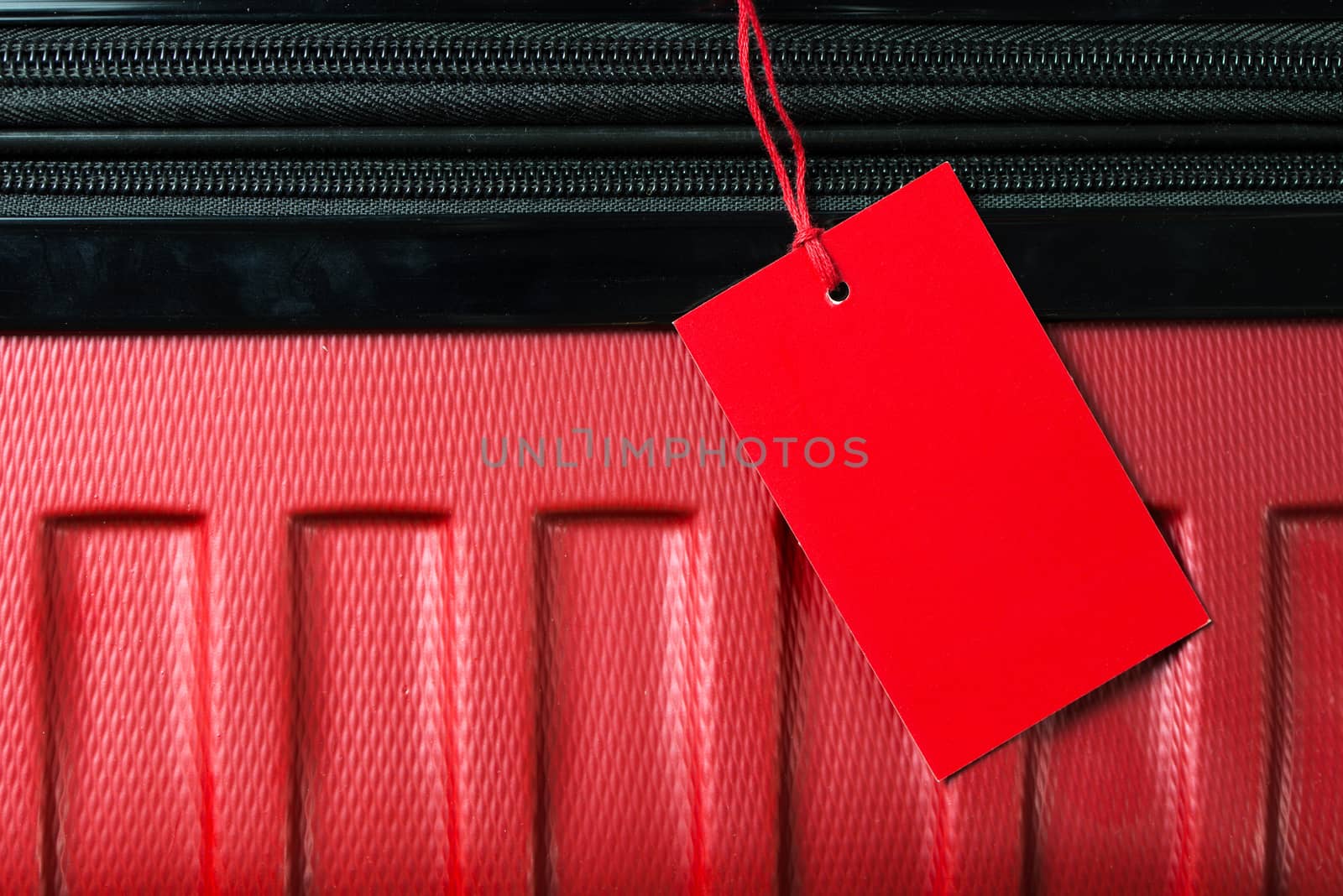Red color empty travel luggage label on handle