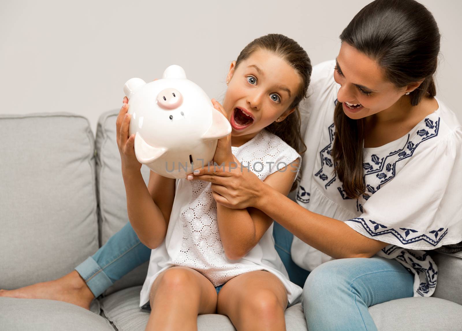 Mother and daughter with a piggy bank for her future savings