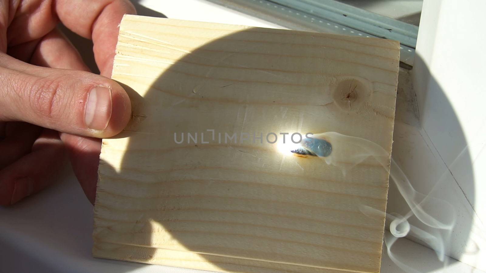 burning on the wood pattern . with the help of magnifying glass burns on a wooden board . sunbeam tree burns. draws with the help of the sun's rays.