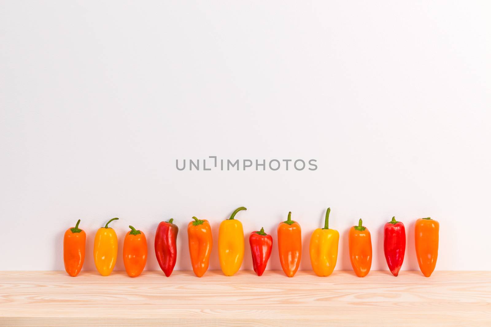 Colorful sweet peppers on wooden surface by anikasalsera