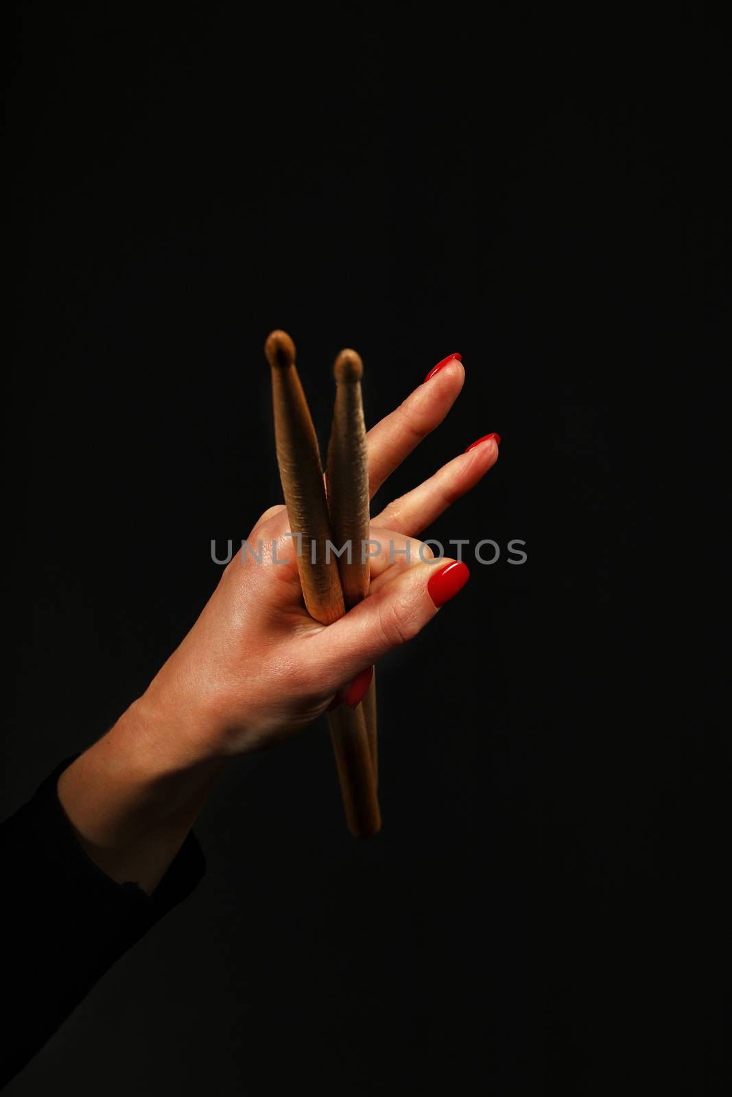 Woman hand with drumsticks, devil horns on black by BreakingTheWalls