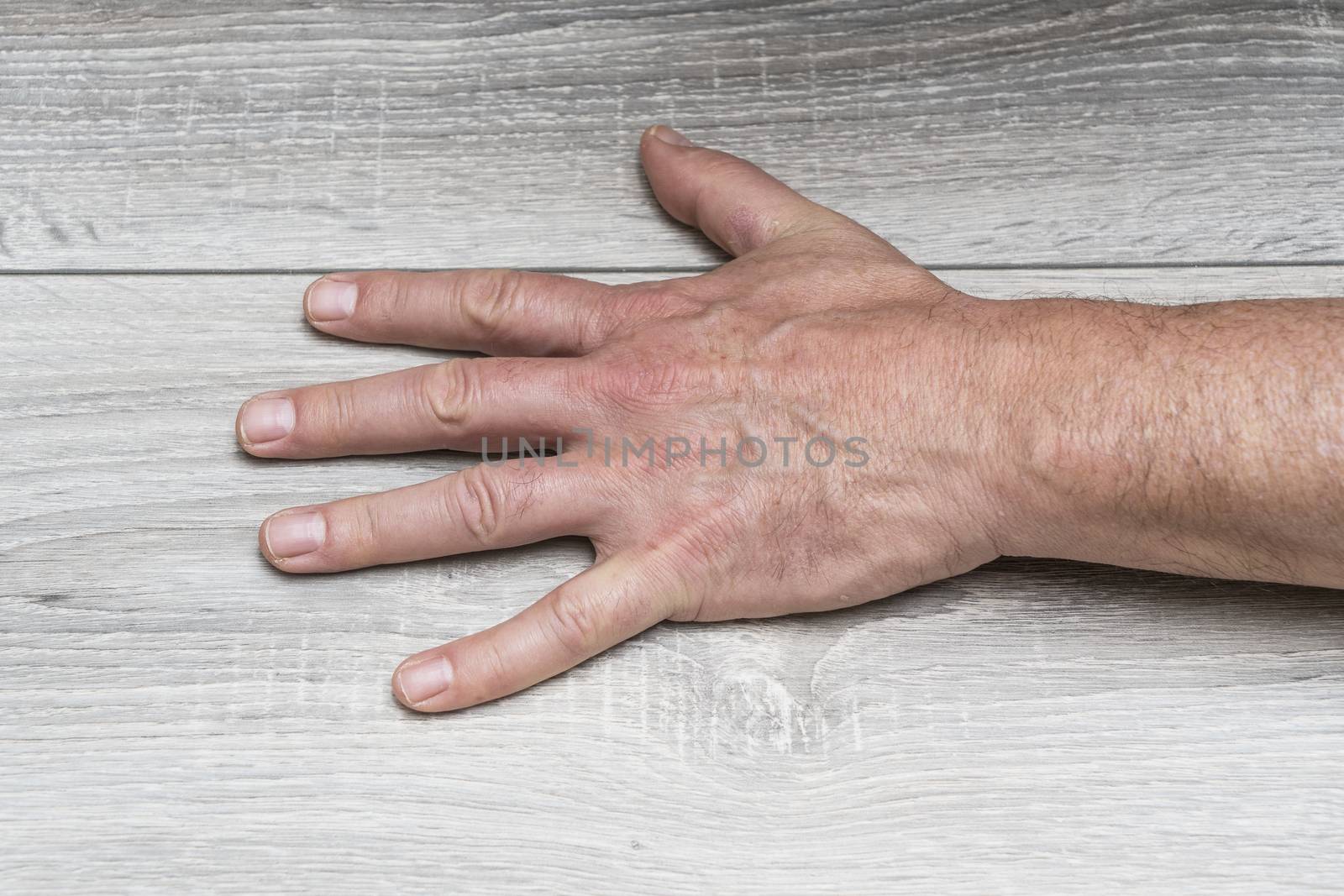 the gesture of a man with his hand resting on the table