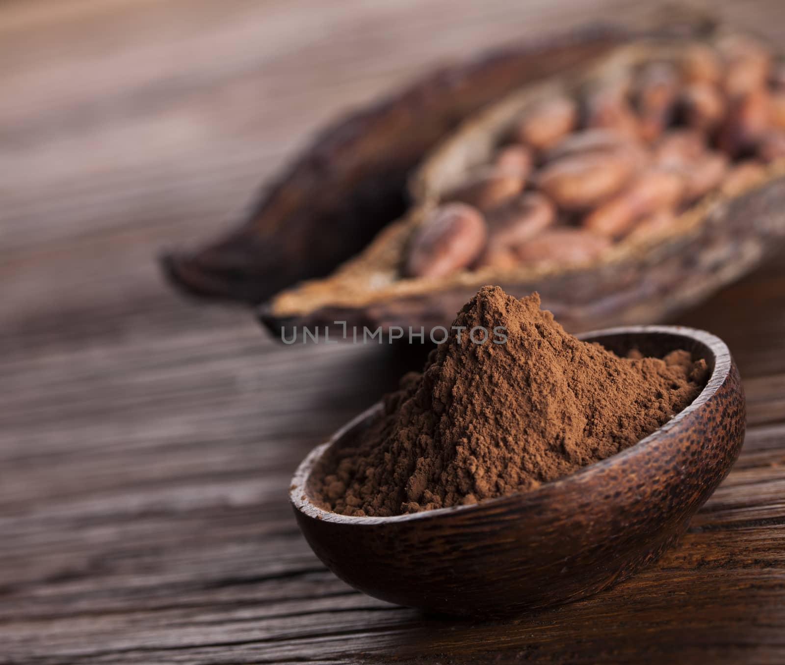 Cocoa beans in the dry cocoa pod fruit on wooden background