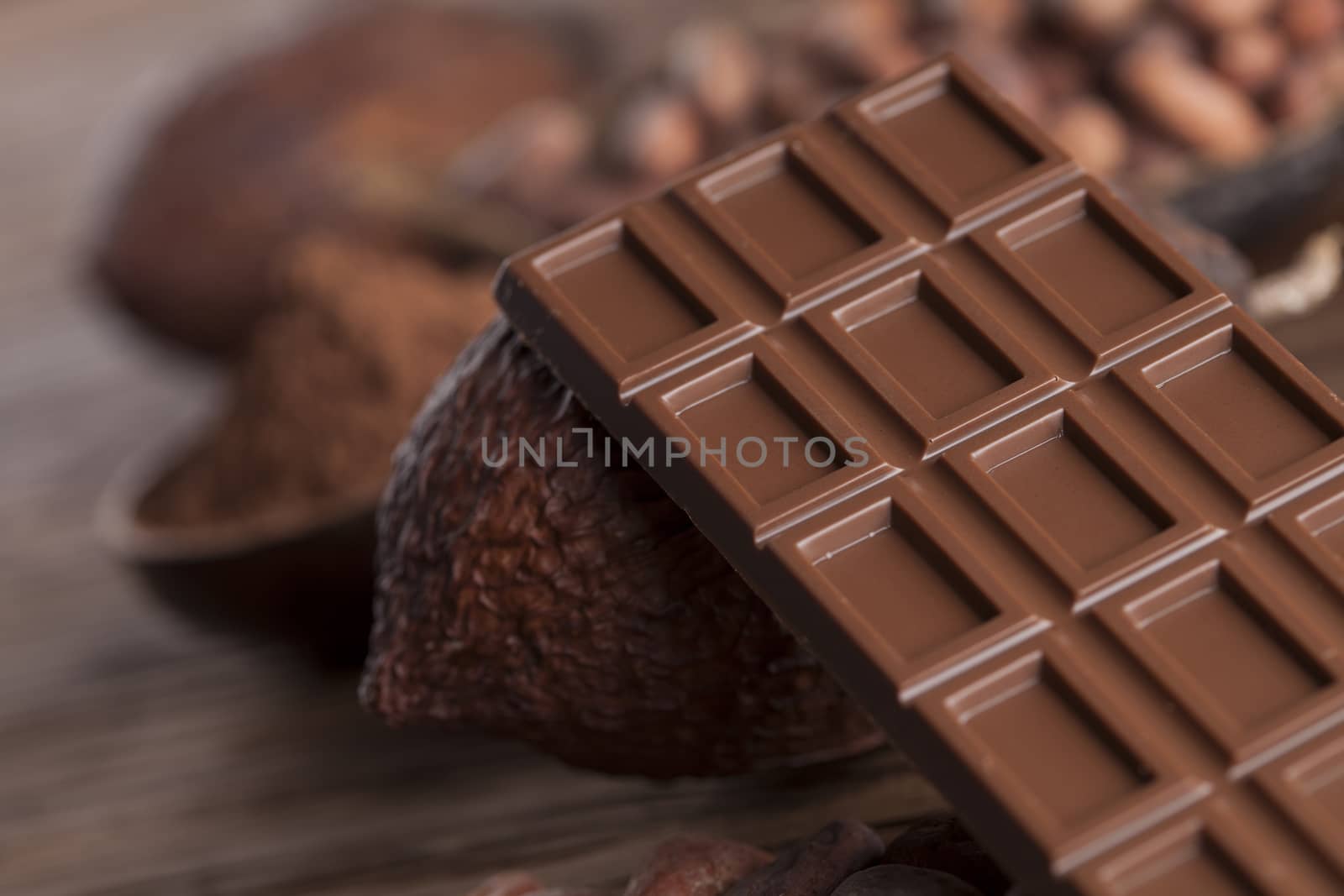 Chocolate bar, candy sweet, cacao beans and powder on wooden bac by JanPietruszka