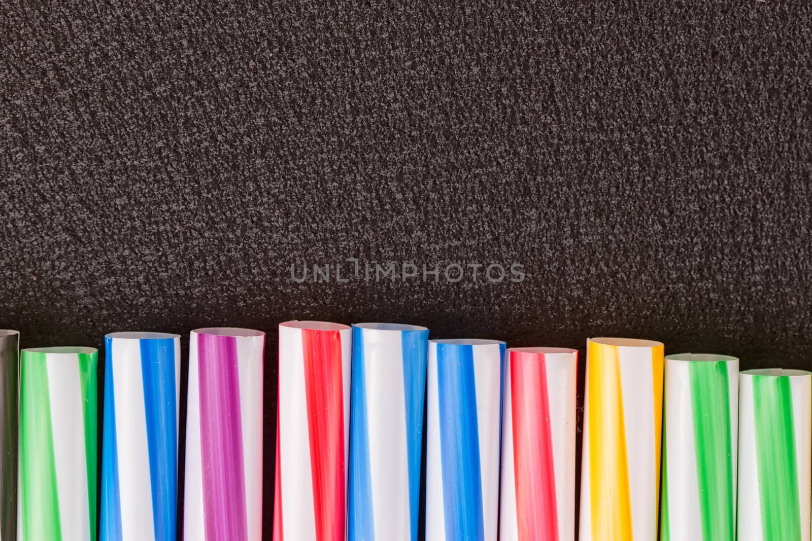 cocktail colorful plastic tube on a black background